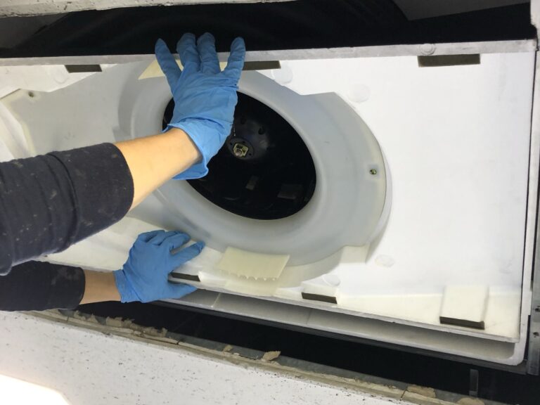 養生を外し、水分を拭き上げてから組み立てる業務用エアコンの作業の様子