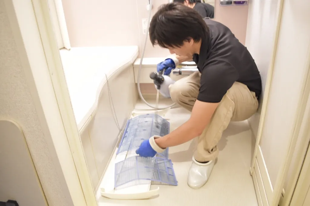 取り外した部品を浴室で洗浄している様子