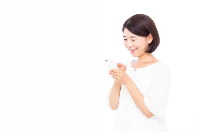 スマートフォンを見る女性（イメージ）