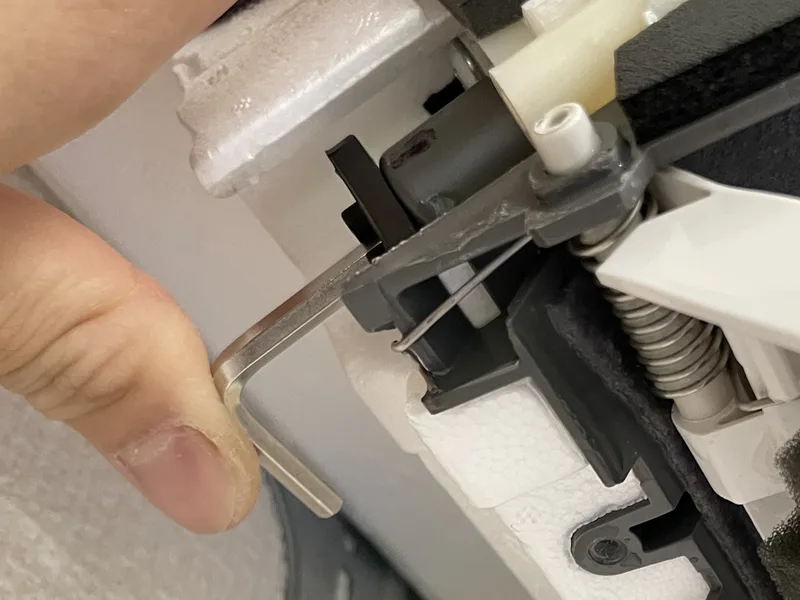 六角レンチで、エアコンのドレンキャップを押し込んでいるところ